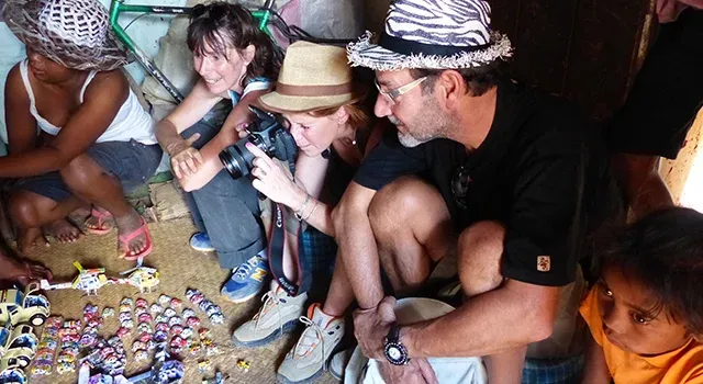 Voyageurs explorant des artisanats locaux colorés à Madagascar avec des enfants