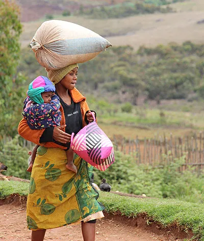 Jeune femme Malgache portant un sac et un bébé